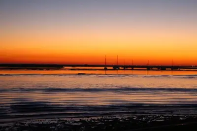 a sunset over a body of water with a pier at Blue Room in Pedralva