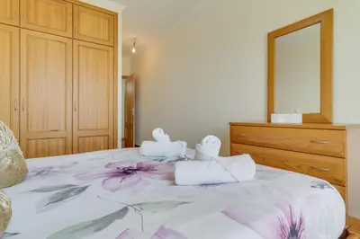 a bedroom with a bed with towels and a dresser at Sunset Horizon by Atlantic Holiday in Estreito de Câmara de Lobos