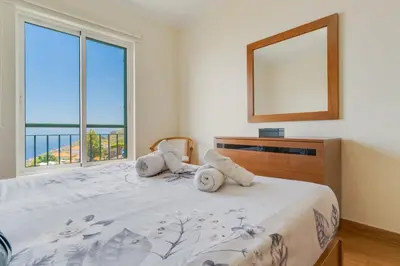 a bedroom with a large bed with a large window at Sunset Horizon by Atlantic Holiday in Estreito de Câmara de Lobos