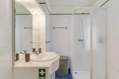 a white bathroom with a sink and a shower at Sunset Horizon by Atlantic Holiday in Estreito de Câmara de Lobos