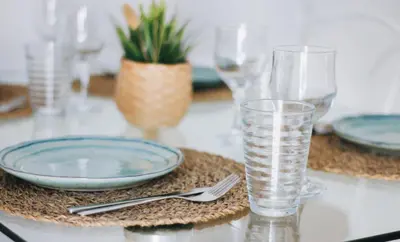 a table with plates and a glass of water at Little Bispo Apartments in Vila do Bispo