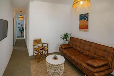 a living room with a brown leather couch and a table at Little Bispo Apartments in Vila do Bispo