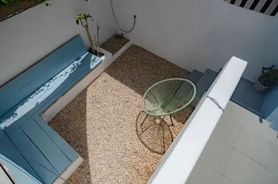 a room with a table and a chair and a pool at Little Bispo Apartments in Vila do Bispo