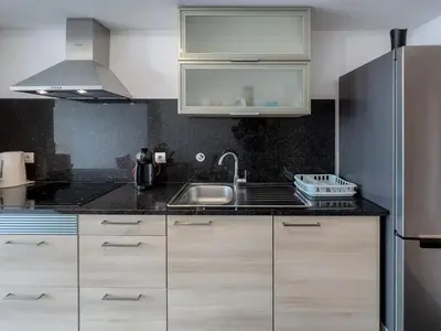 a kitchen with a sink and a stainless steel refrigerator at GuestReady - Paradisus Residence Atlantic Retreat in Caniço