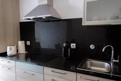 a kitchen with a black counter top and a sink at GuestReady - Paradisus Residence Atlantic Retreat in Caniço