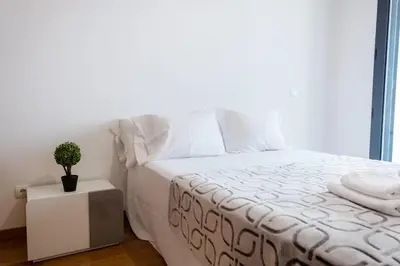 a bedroom with a white bed with a potted plant on a night stand at GuestReady - Paradisus Residence Atlantic Retreat in Caniço