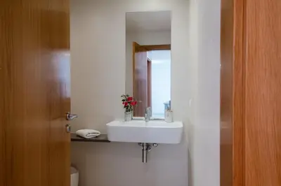 a bathroom with a white sink and a mirror at GuestReady - Paradisus Residence Atlantic Retreat in Caniço
