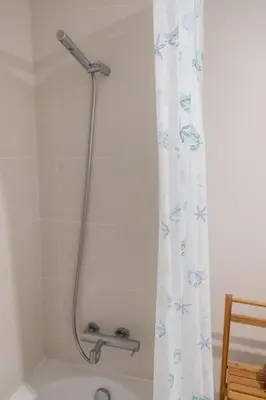 a shower curtain in a bathroom with a tub at GuestReady - Paradisus Residence Atlantic Retreat in Caniço