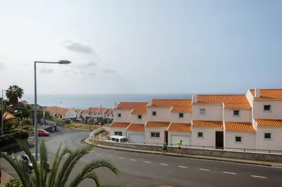 two people walking down a street next to houses at GuestReady - Paradisus Residence Atlantic Retreat in Caniço