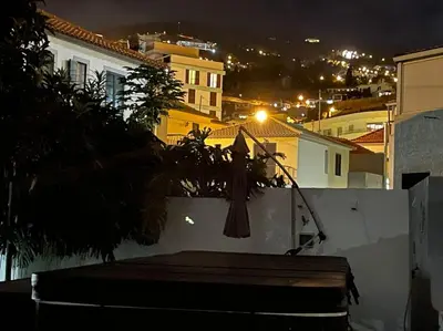 a small kitchen with a refrigerator and a window at Casa do Til, central Funchal in Funchal