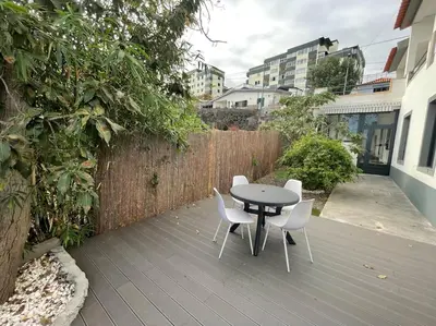 a patio with a table and chairs and a fence at Casa do Til, central Funchal in Funchal
