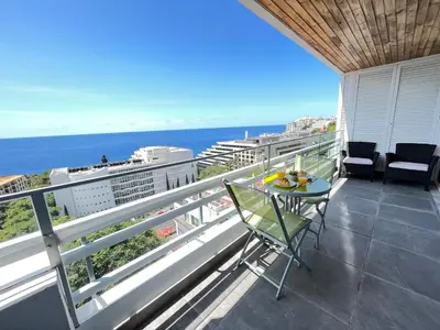 a balcony with a table and chairs and the ocean at Lido Sol 318 in Funchal