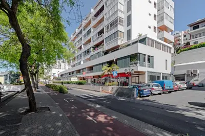 a city street with cars parked in front of a building at Lido Sol 318 in Funchal