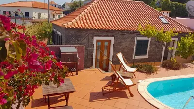 a house with a swimming pool next to a house at Casa Luciana in Ponta do Pargo