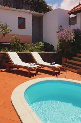 two lounge chairs sitting next to a swimming pool at Casa Luciana in Ponta do Pargo
