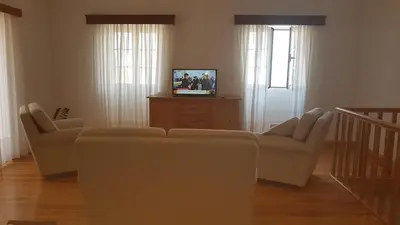 a living room with a couch and a tv at Casa Luciana in Ponta do Pargo