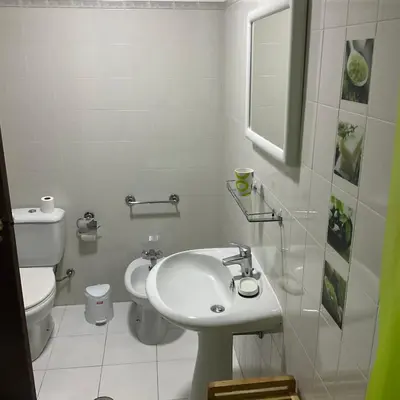a white bathroom with a sink and a toilet at Sea to see - sea front view in Caniço