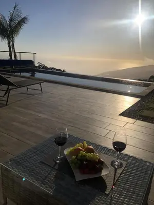 a plate of food and two glasses of wine on a table at Casa da Arvore in Arco da Calheta