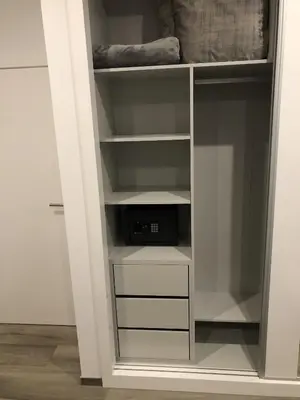a closet with white shelves and a microwave at Casa da Arvore in Arco da Calheta