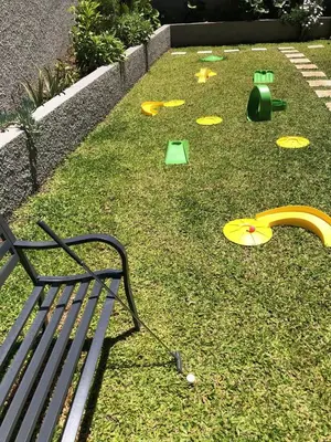 a park with a bench and play equipment on the grass at Casa da Arvore in Arco da Calheta