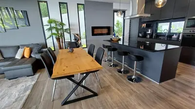 a kitchen and living room with a wooden table at Casa da Arvore in Arco da Calheta