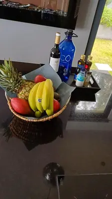 a basket of fruit on a counter with bottles of alcohol at Casa da Arvore in Arco da Calheta