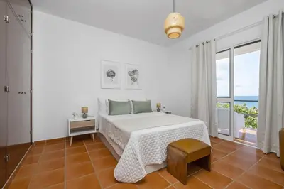 a white bedroom with a bed and a large window at Villa Bella Mar by Homie in Porto Santo