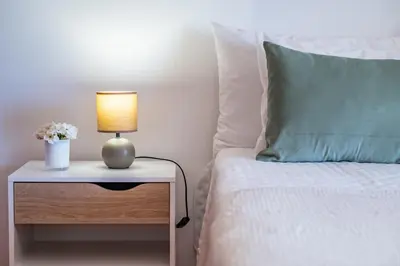 a bed with a table with a lamp and a pillow at Villa Bella Mar by Homie in Porto Santo