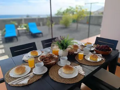 a table with plates of food and drinks on it at Villa Bella Mar by Homie in Porto Santo