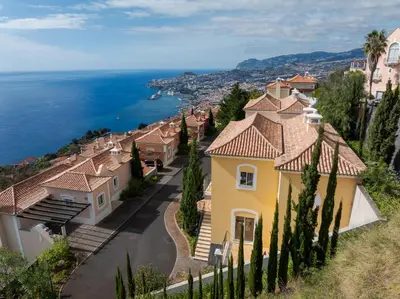 an aerial view of a house with a swimming pool and the ocean at Villa Gasparini Palheiro Village by Holiday Rental Madeira in Funchal