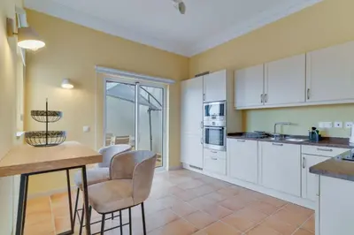 a dining room with a table and chairs and a sliding glass door at Villa Gasparini Palheiro Village by Holiday Rental Madeira in Funchal