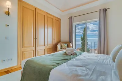 a bedroom with a bed with a teddy bear on it at Villa Gasparini Palheiro Village by Holiday Rental Madeira in Funchal