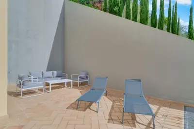 two blue chairs and a couch in a room at Villa Gasparini Palheiro Village by Holiday Rental Madeira in Funchal