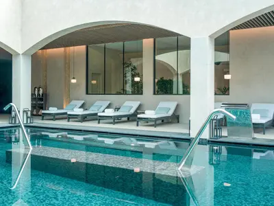 a hotel swimming pool with chairs and tables at Dreams Madeira Resort Spa & Marina in Caniçal