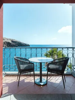 a balcony with a table and chairs and the ocean at Dreams Madeira Resort Spa & Marina in Caniçal