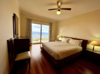 a bedroom with a bed with a ceiling fan and a window at Casa Darcey by Your Madeira Rentals in Estreito da Calheta