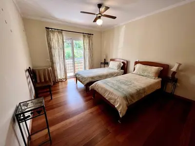 a bedroom with two beds and a ceiling fan at Casa Darcey by Your Madeira Rentals in Estreito da Calheta