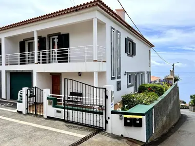 a white house with a fence in front of it at Casa Darcey by Your Madeira Rentals in Estreito da Calheta