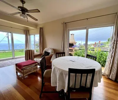 a living room with a table and a view of the ocean at Casa Darcey by Your Madeira Rentals in Estreito da Calheta