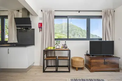 a living room with a television and a table with a stool at Basalt Dwelling I by Homie in São Vicente