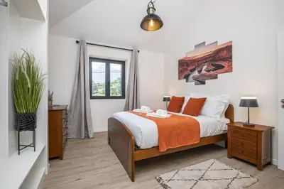 a bedroom with a bed with an orange blanket at Basalt Dwelling I by Homie in São Vicente