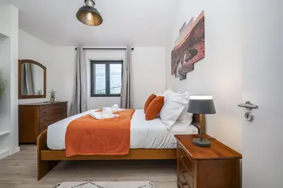 a bedroom with a bed and a table with a lamp at Basalt Dwelling I by Homie in São Vicente