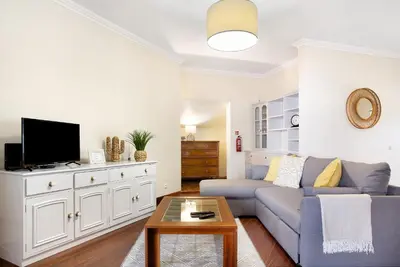 a living room with a blue couch and a tv at Penthouse Vista Mar in Funchal