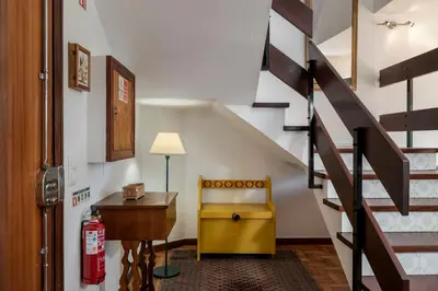 a living room with a yellow chair and stairs at Matur I by An Island Apart in Água de Pena
