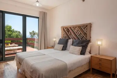 a bedroom with a large bed and a balcony at Matur I by An Island Apart in Água de Pena