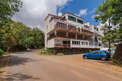 a building with a blue car parked in front of it at Matur I by An Island Apart in Água de Pena