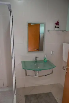 a bathroom with a green sink and a mirror at Villas Horizonte Capazi in Porto Santo