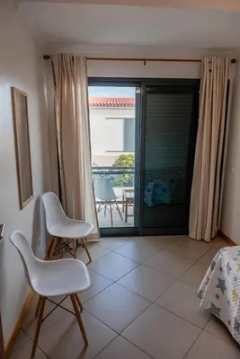 a room with two chairs and a view of a patio at Villas Horizonte Capazi in Porto Santo