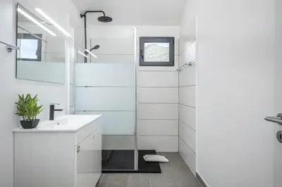 a white bathroom with a sink and a shower at Basalt Dwelling II by Homie in São Vicente