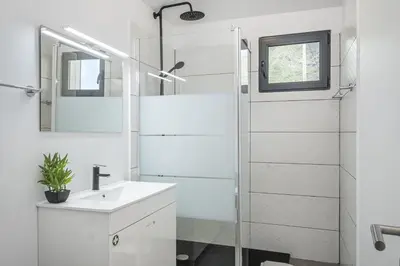 a white bathroom with a sink and a shower at Basalt Dwelling II by Homie in São Vicente